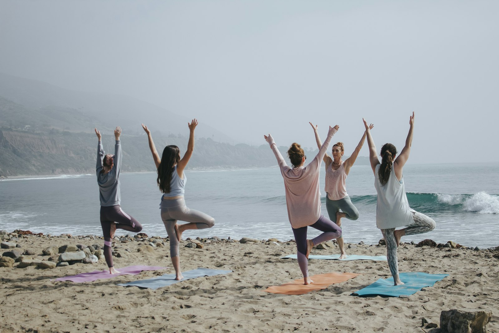 A group practising together by the sea — emotional well-being in motion